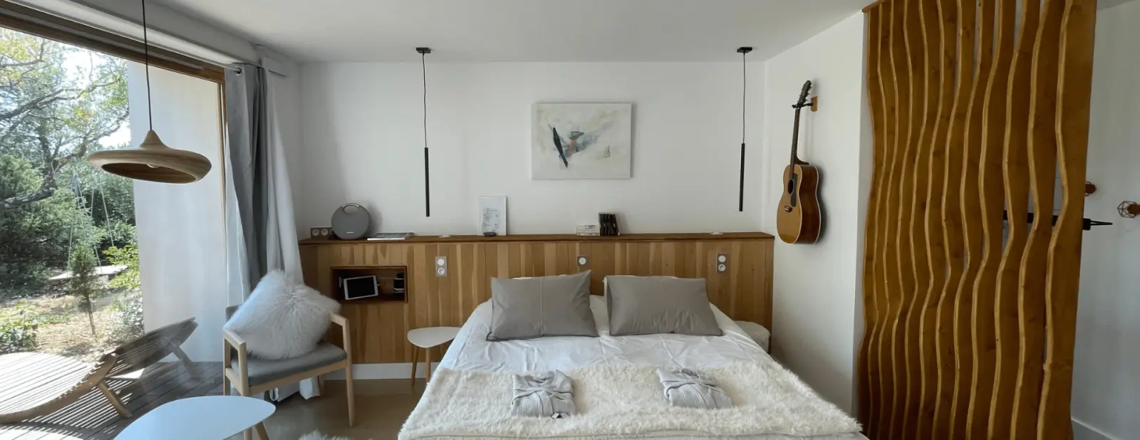 Ellos room at 4U Bed&Spa: bed, wooden headboard, guitar and wavy wooden screen