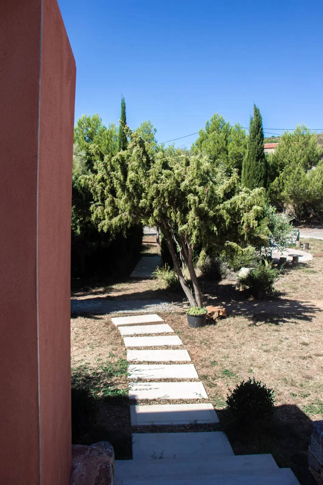 Stepping-stone path through the Mediterranean garden at 4U Bed&Spa, with cypresses and pines