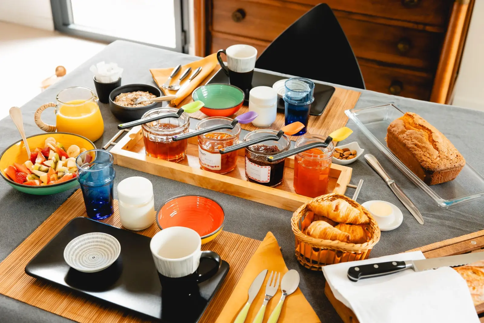 Breakfast at Bread et Couette with a tray of jams, fruit salad, loaf cake, croissants and orange juice