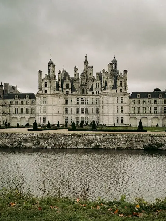 Le château de Chambord sous un ciel gris, vu de l'autre rive de l'eau