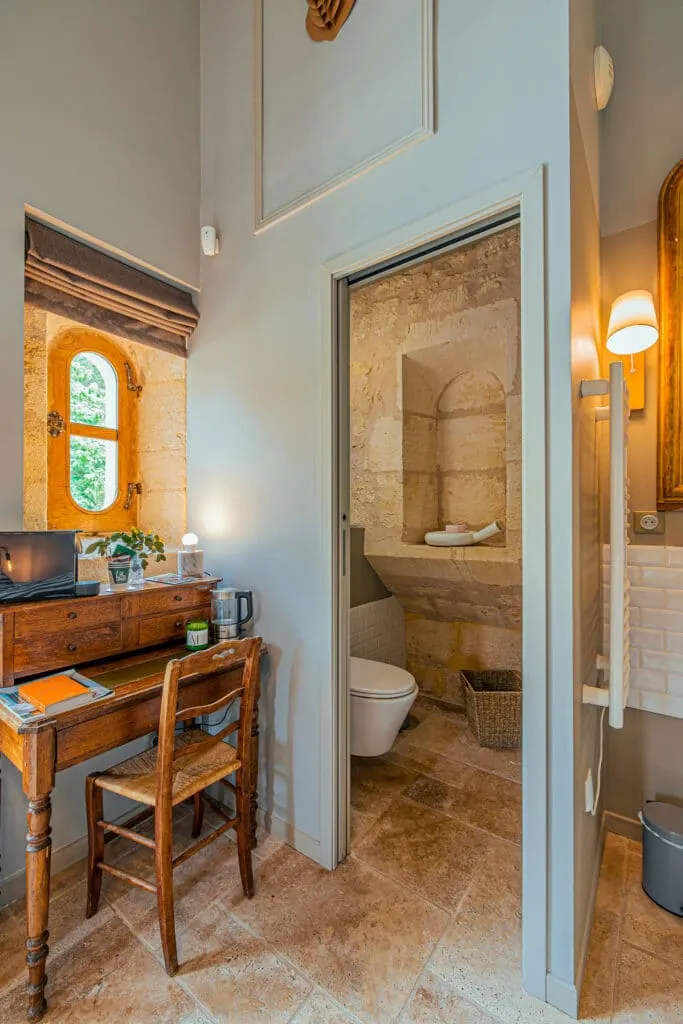 Desk corner of the Côté Jardin room at Clos Marcamps, antique desk, stone window and adjoining WC