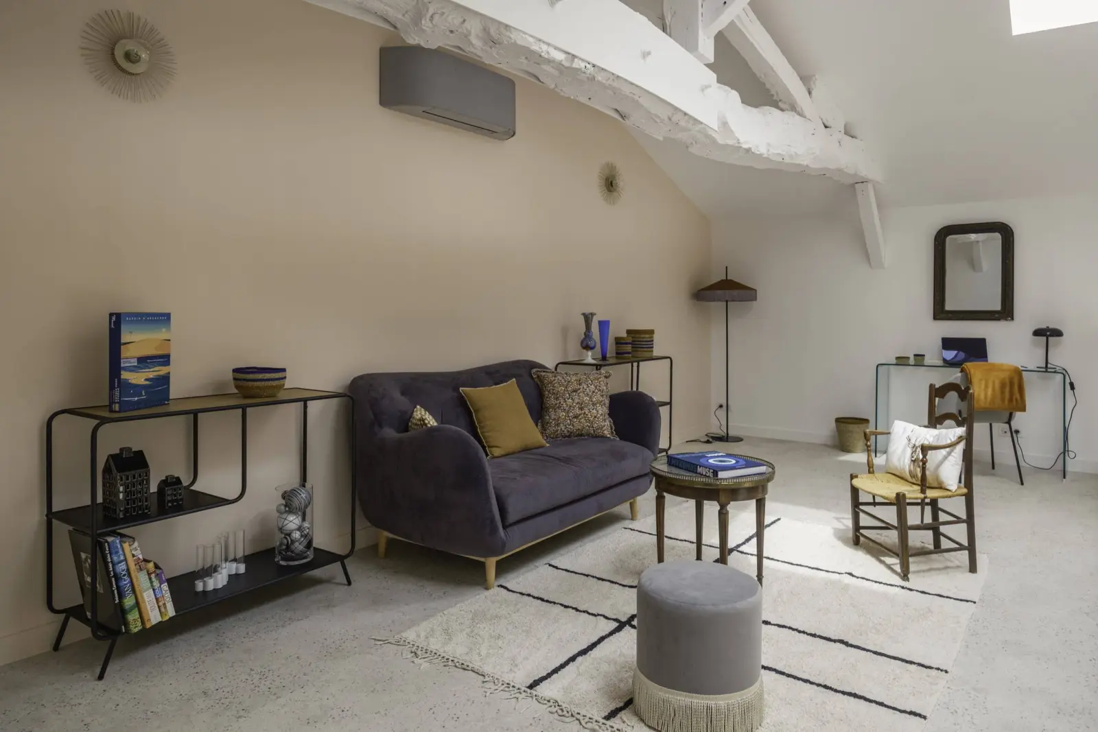 Mezzanine of the shared lounge at Clos Marcamps with white beams, grey sofa, Berber rug and desk corner