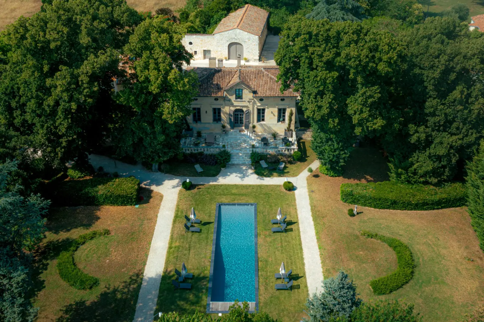 Drone view of Clos Marcamps: manor house, paths and rectangular pool in the middle of the lawn