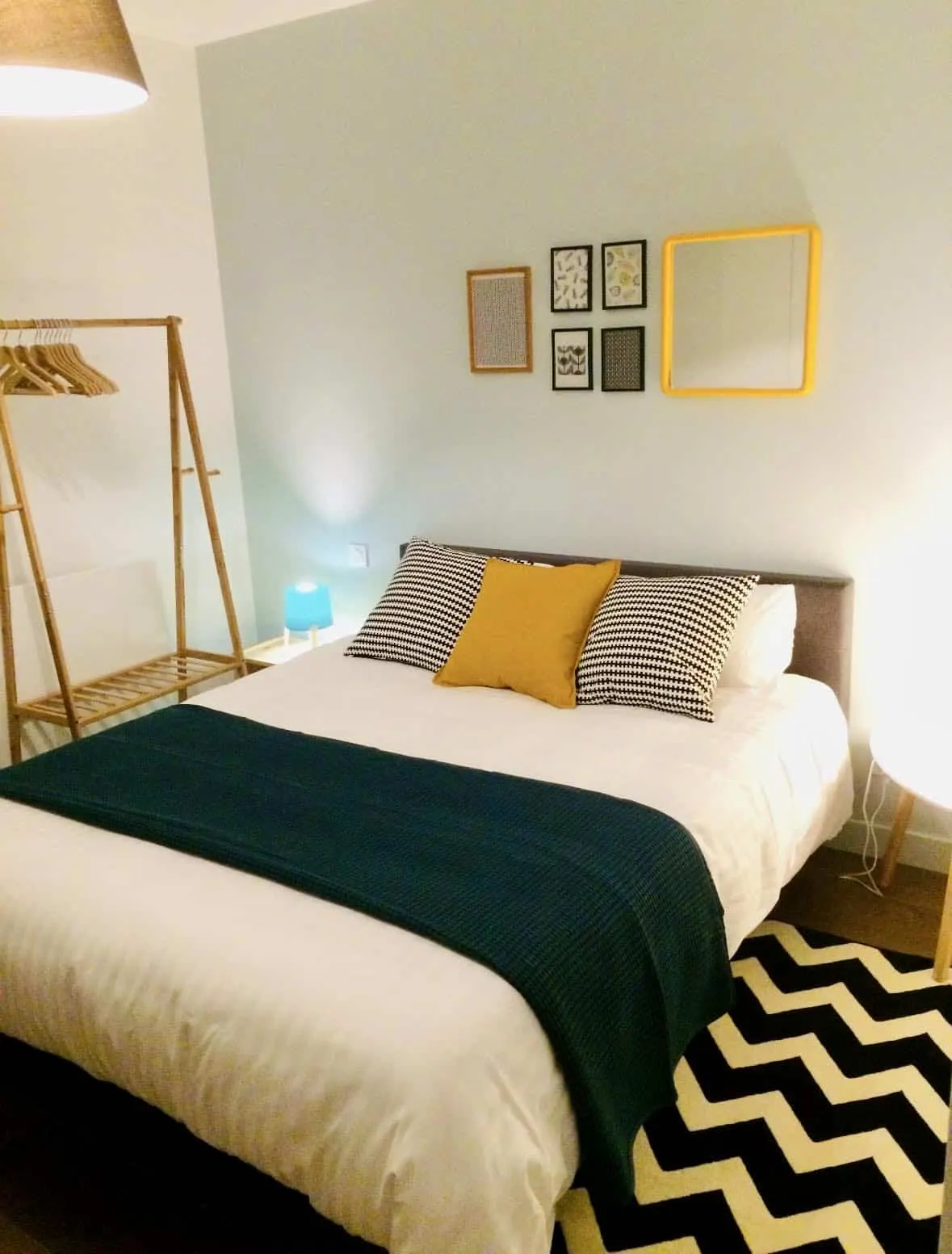 Bedroom at Effet Lodge: double bed, green throw, mustard cushion and black and white chevron rug
