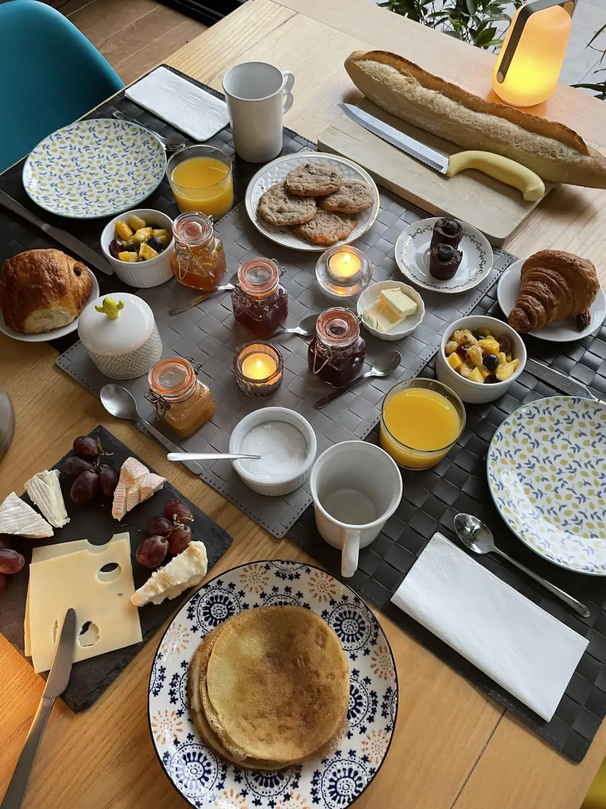 Effet Lodge breakfast table with pancakes, baguette, croissants, orange juice and jams