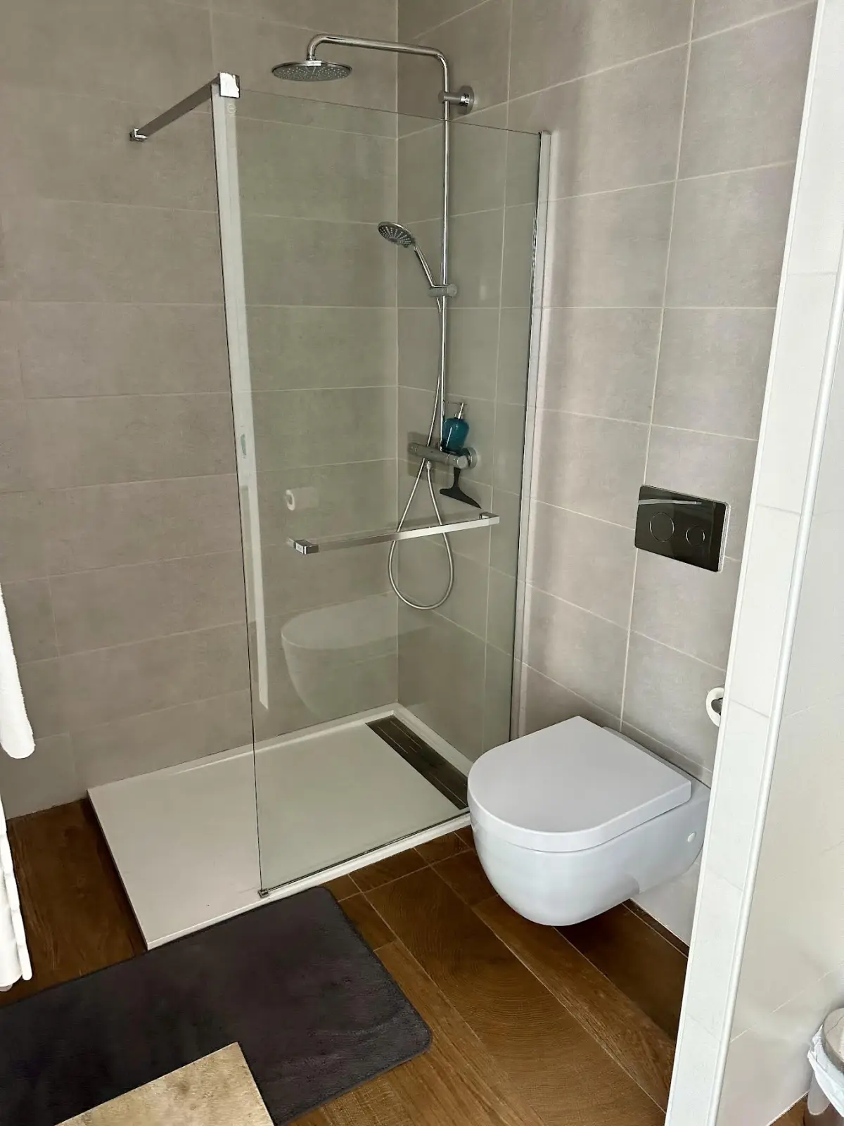 Effet Lodge bathroom with a glass walk-in shower, wall-hung WC and beige tiles