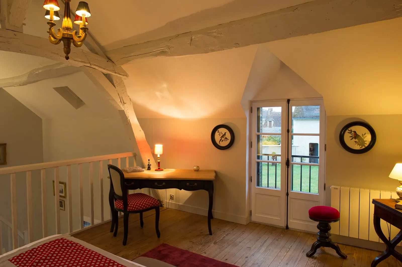 Antique desk and red chair under the beams, French window onto the garden, La Folie Saint Julien