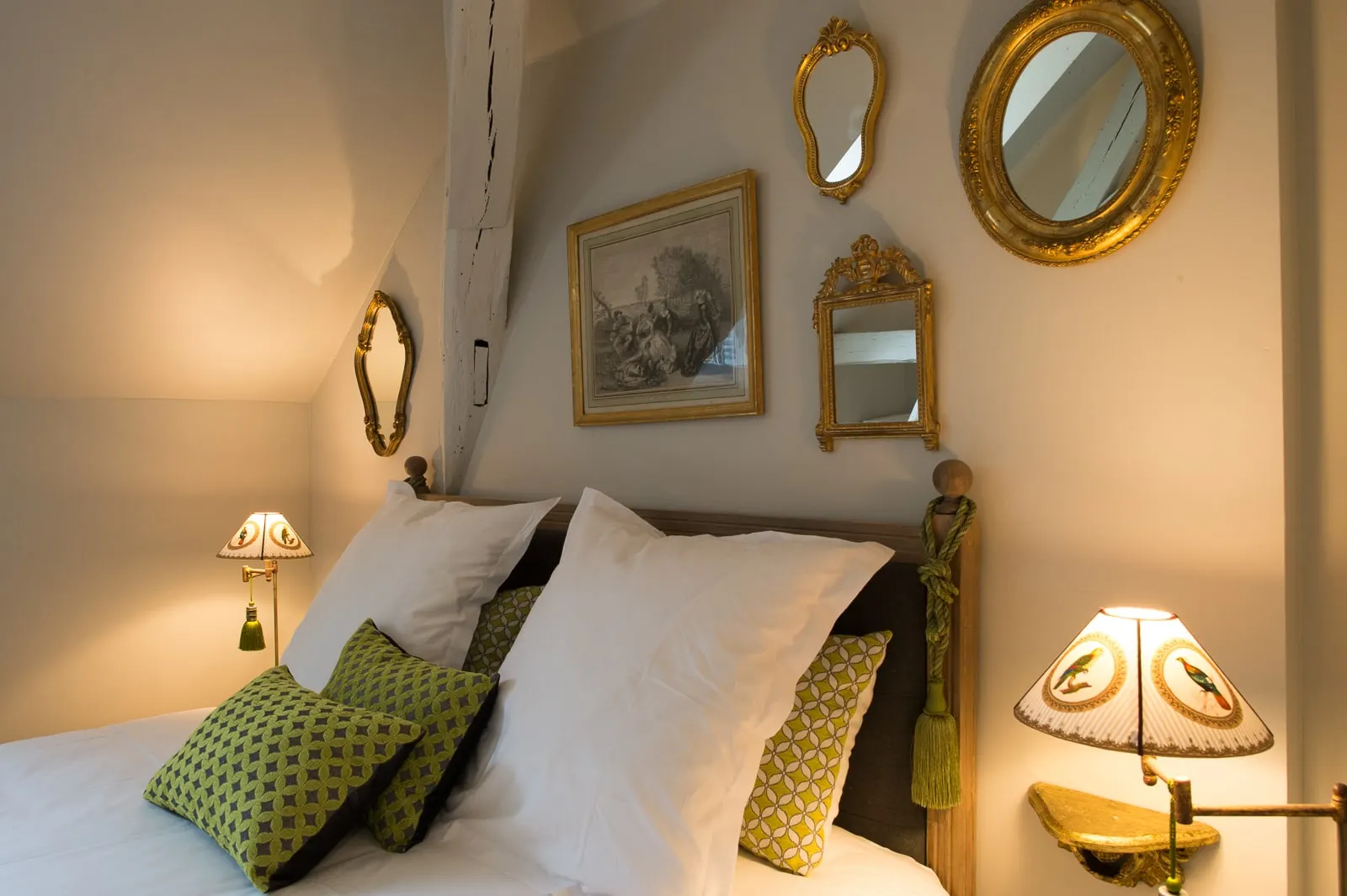 Headboard, green and yellow cushions, gilt mirrors and a framed print, La Folie Saint Julien