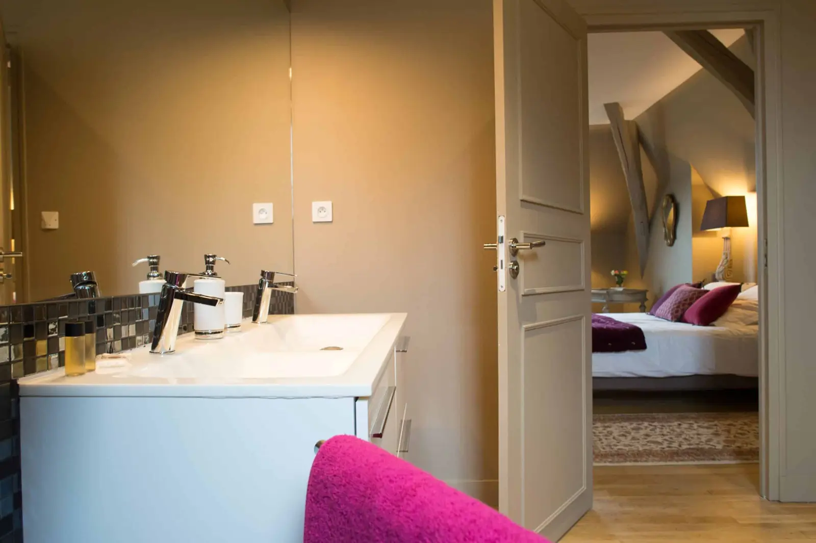 Bathroom with a white double basin and a door open onto the bedroom, La Folie Saint Julien