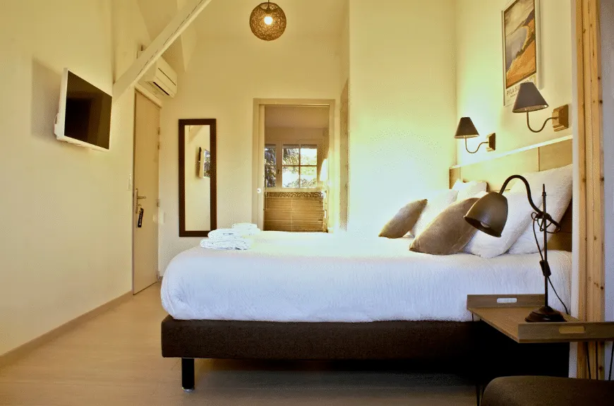 Bedroom at Villa Glen Tara with double bed, wooden beam, wall-mounted TV and reading lamp