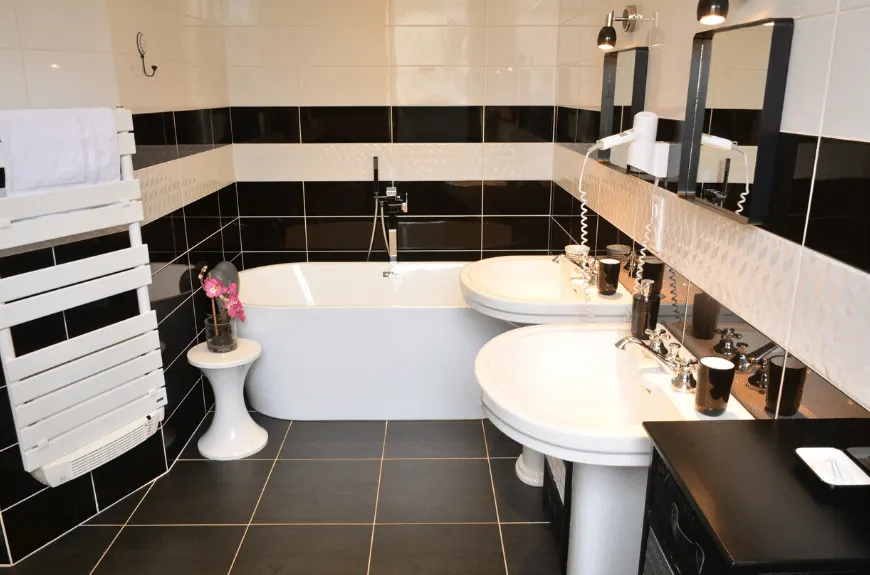 Black and white bathroom with freestanding bath, two pedestal basins and towel rail, Villa Glen Tara