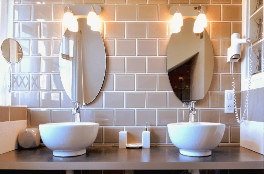 Bathroom with two white basins, oval mirrors and taupe tiles, Villa Glen Tara