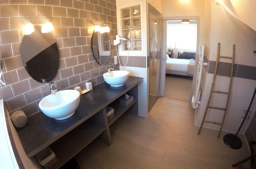 Bathroom with two basins, brown tiles, wooden ladder and door open to the bedroom, Villa Glen Tara
