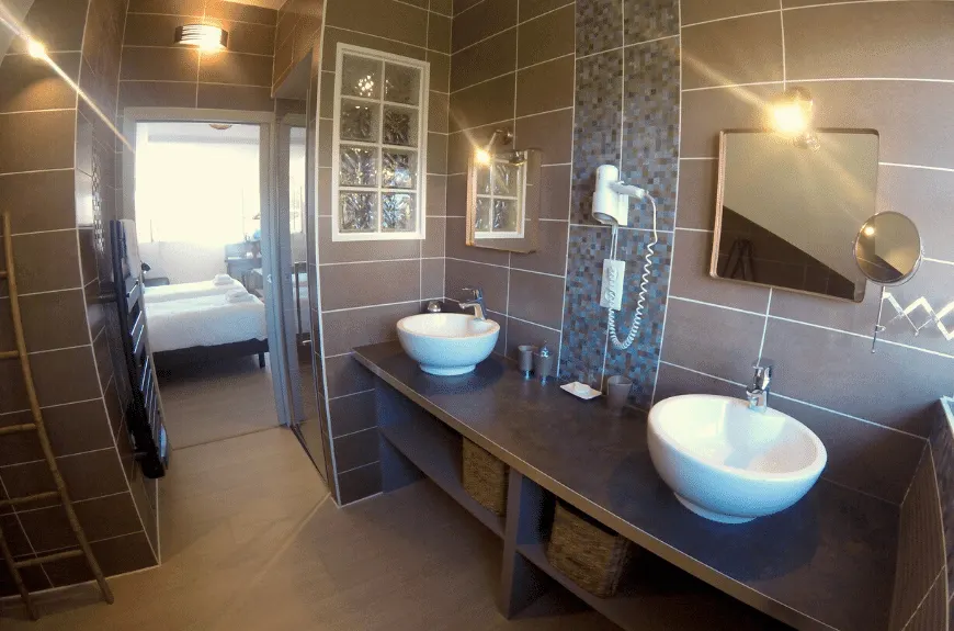 Bathroom with two white basins and glass blocks, opening onto the bedroom, Villa Glen Tara