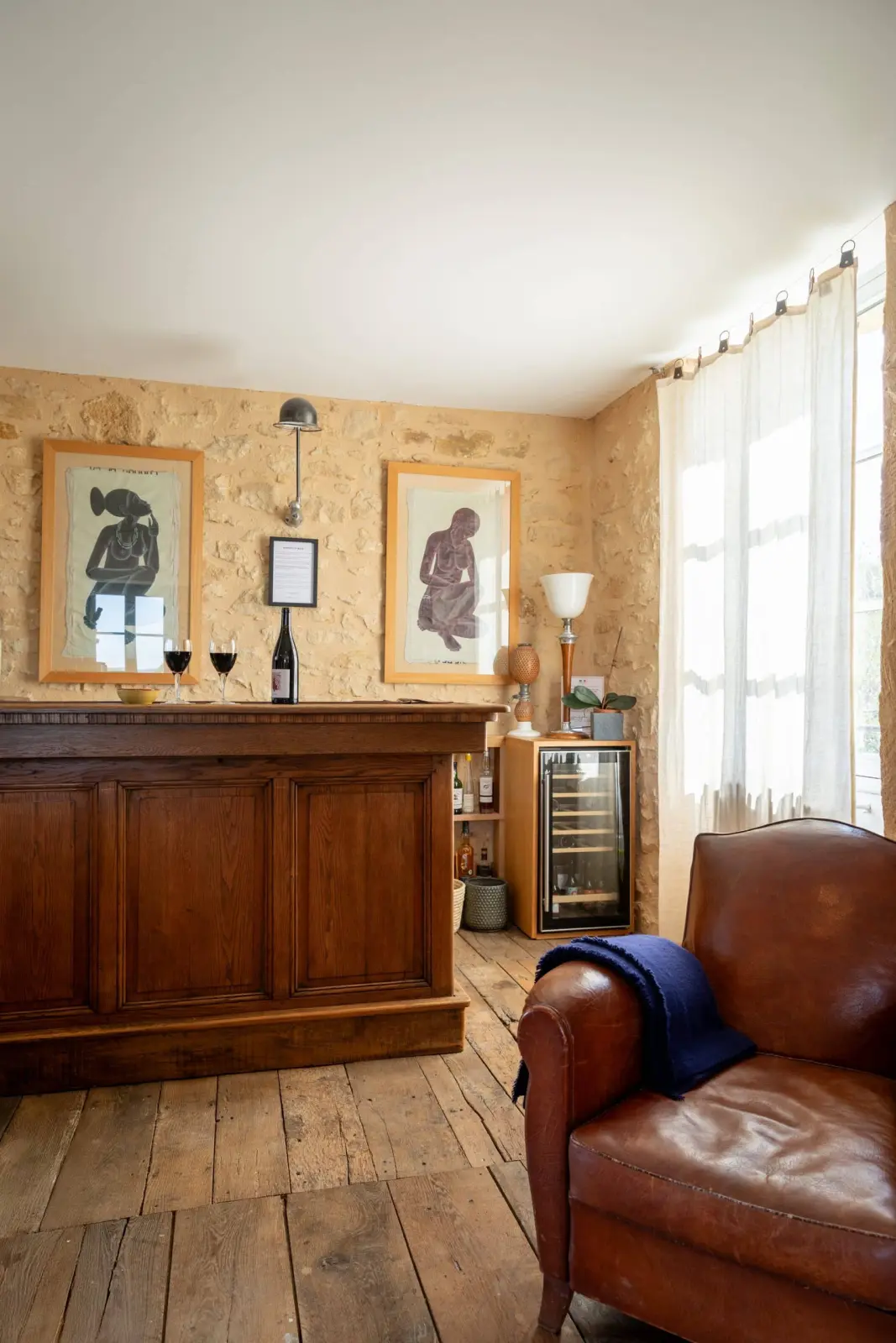 Lounge bar at Les Hauts de Saint-Vincent: wooden counter, wine fridge, leather club chair and stone walls