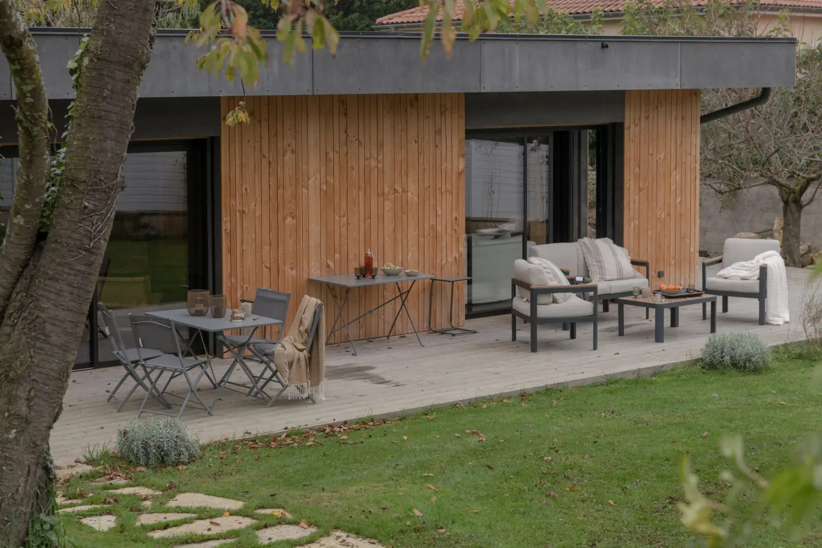 Timber-clad gîte at La Maison des Monts d'Or: decking, garden table and outdoor lounge seating