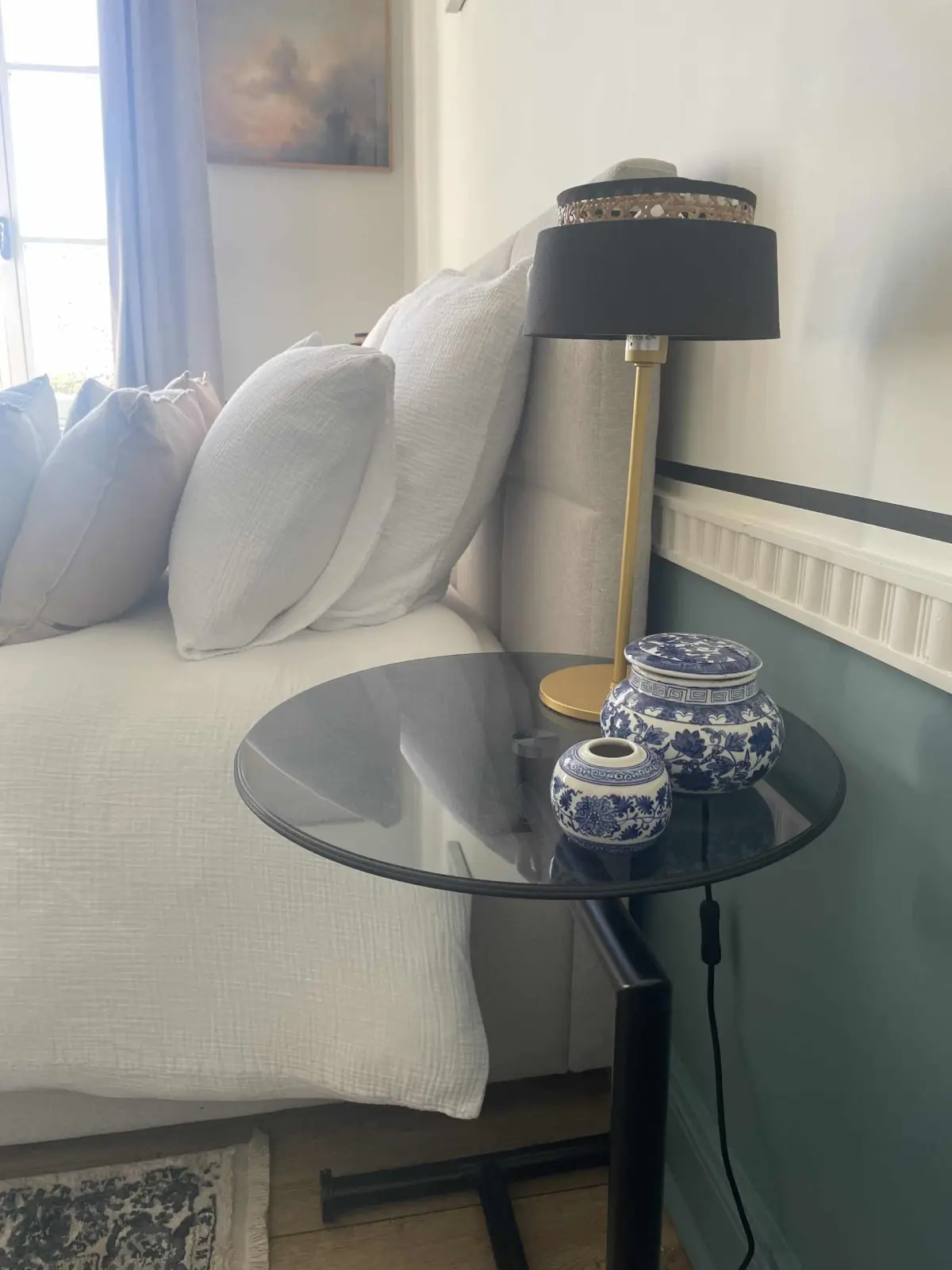 Bedside in the Honfleur room at Marculfo, smoked-glass side table, gold lamp and blue china pots