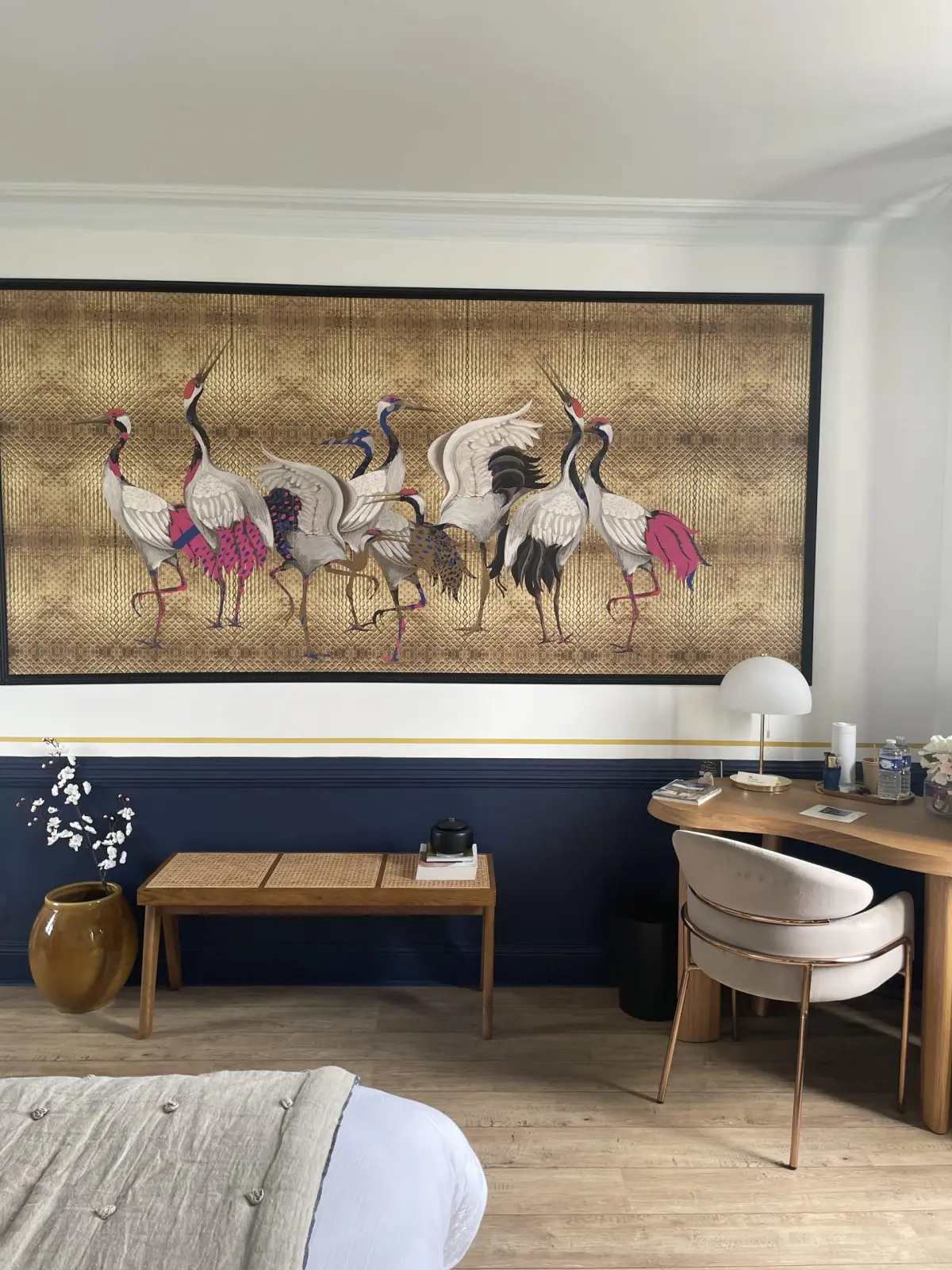 Panel of cranes on a gold ground above a cane bench and a desk in the Houlgate room at Marculfo