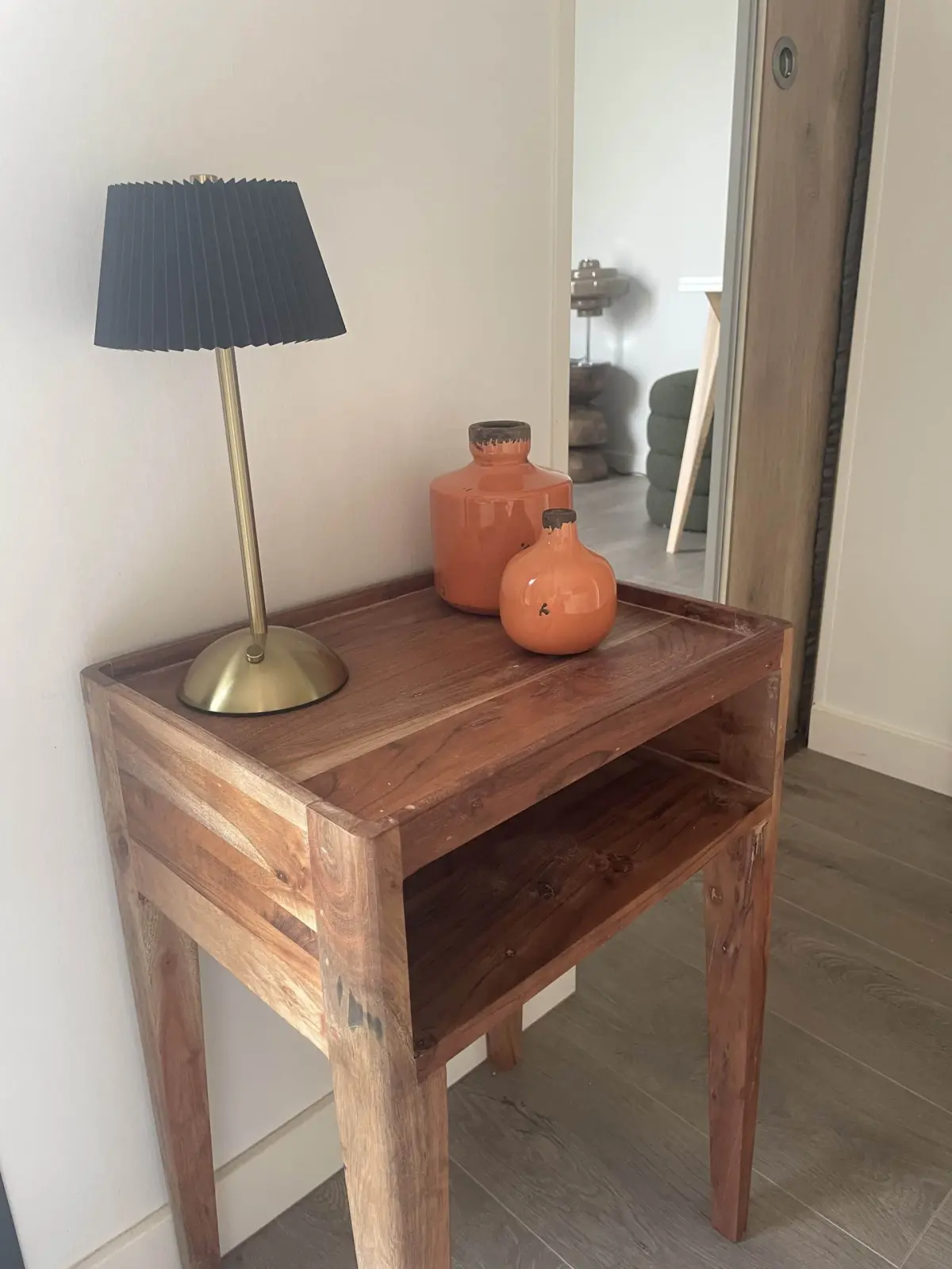 Wooden console in the lodge at Domaine de Marculfo, black pleated lamp and orange ceramic vases