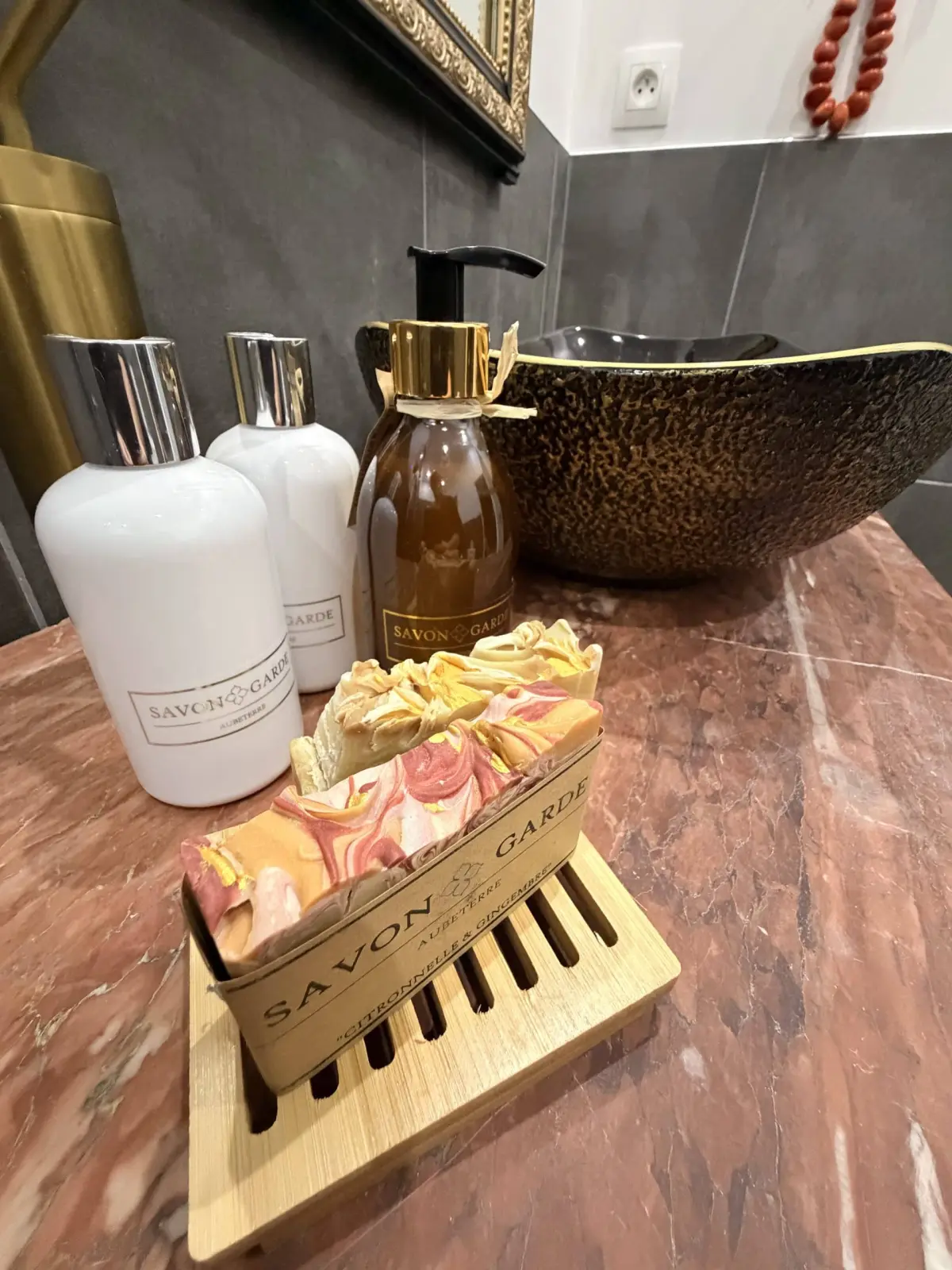 Hammered copper basin, handmade soaps and Savon de Garde bottles on a marble top, Le Patio Bleu