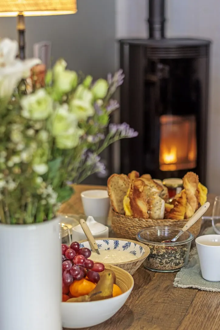 Breakfast at La Plonplonière: a bouquet, toast, fruit and yoghurt before a lit wood-burning stove