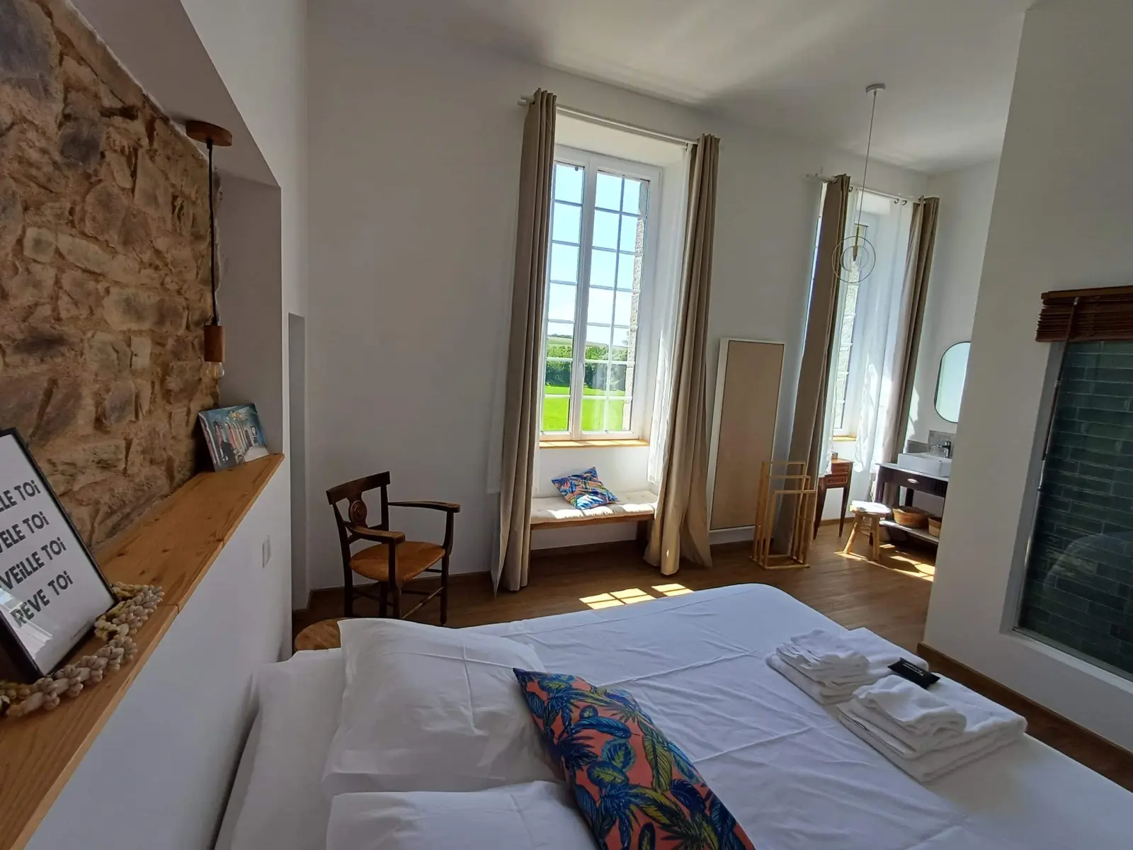 Bouli Boula room at Ty Monde with stone wall, double bed and tall windows onto the countryside