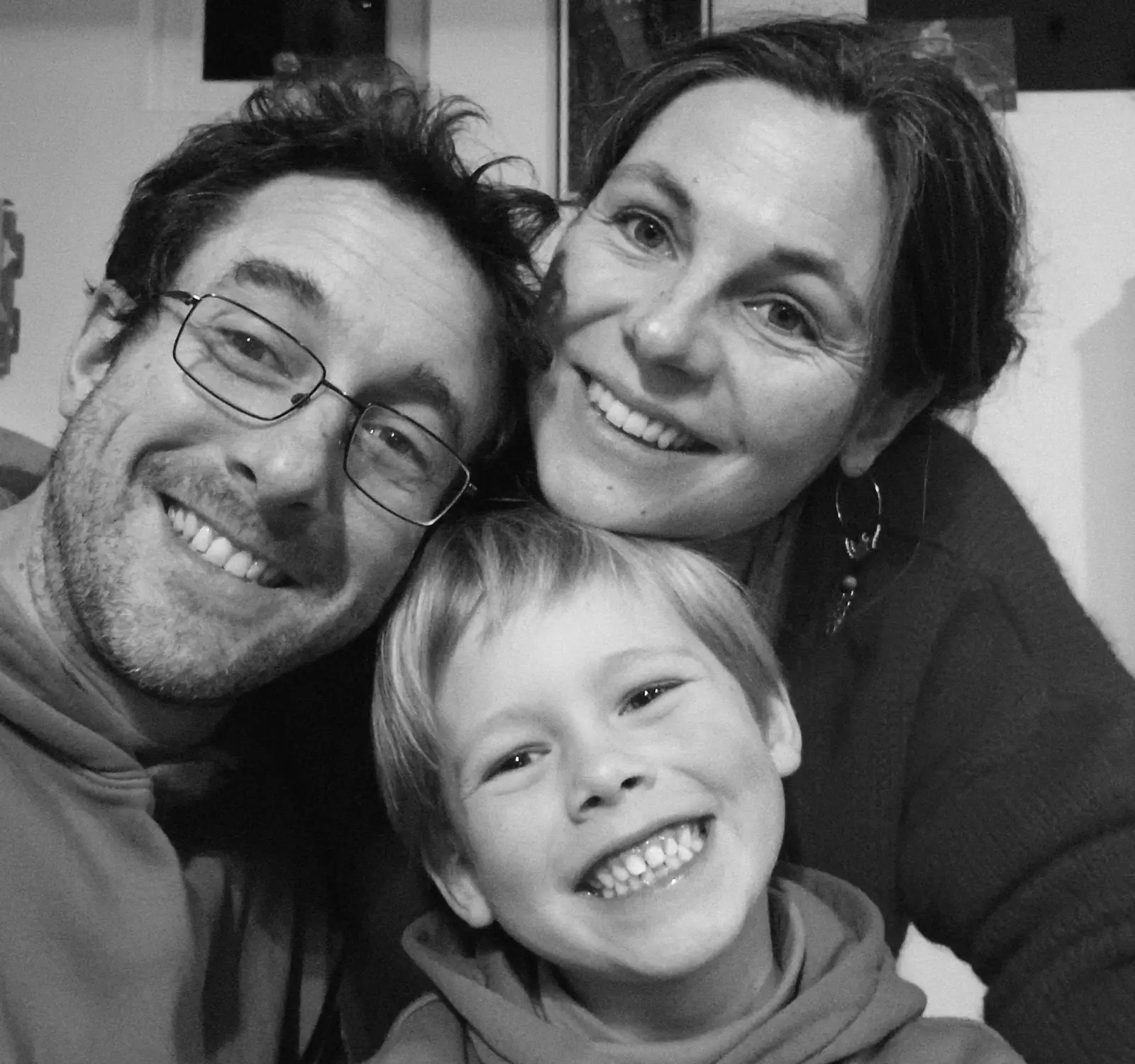 Black and white portrait of a smiling couple with their young son, the hosts of Ty Monde