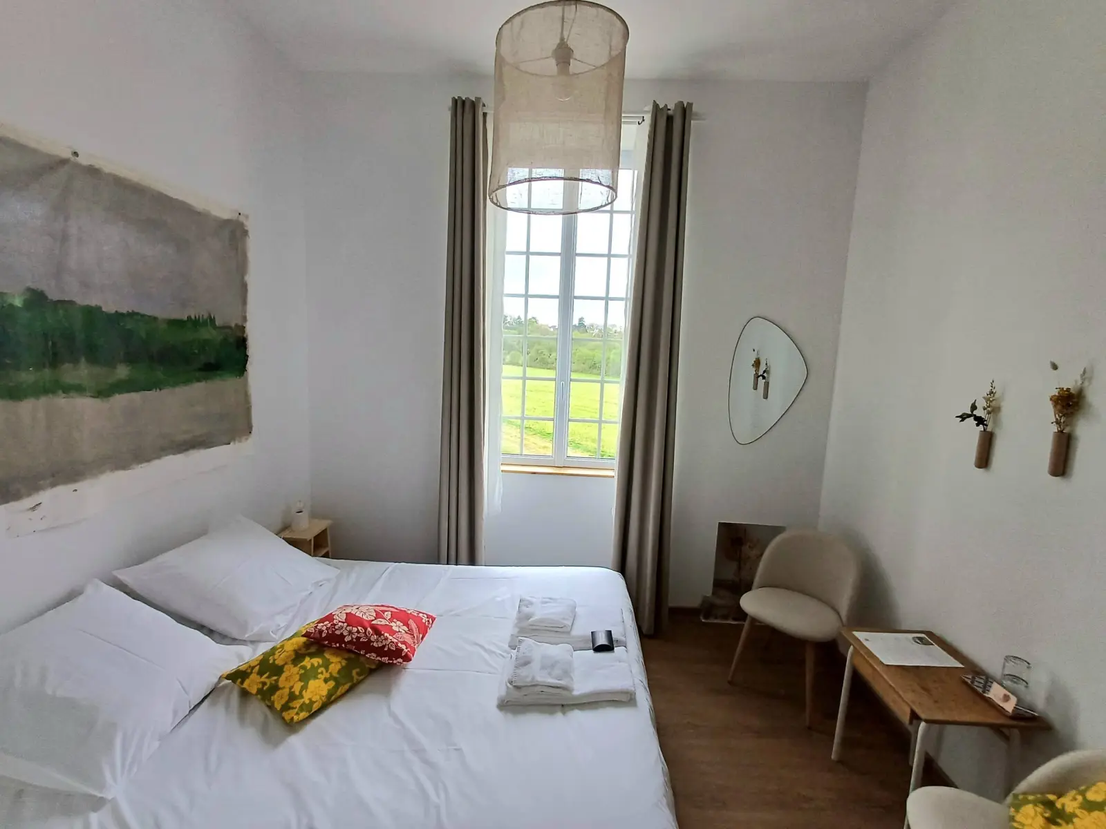 Ia Orana room at Ty Monde: double bed, colourful cushions, large landscape canvas and countryside window