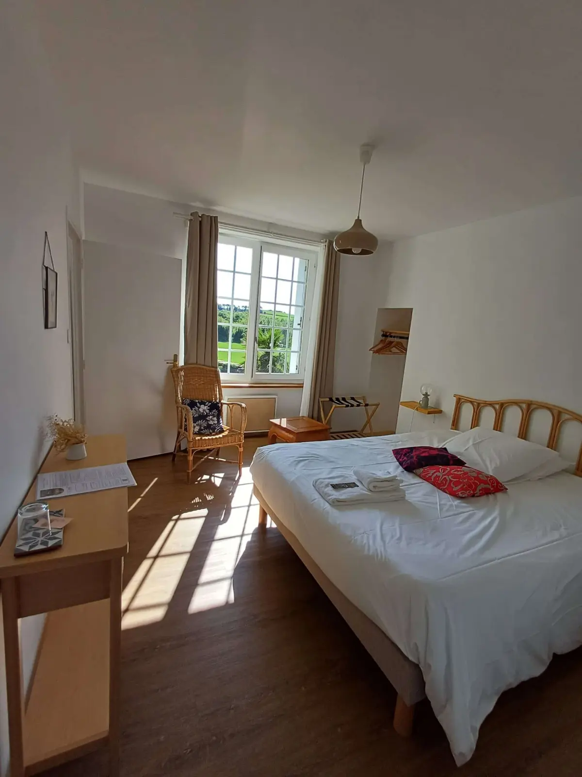 Mamm Gozh family suite at Ty Monde: double bed, wicker armchair and window onto the countryside