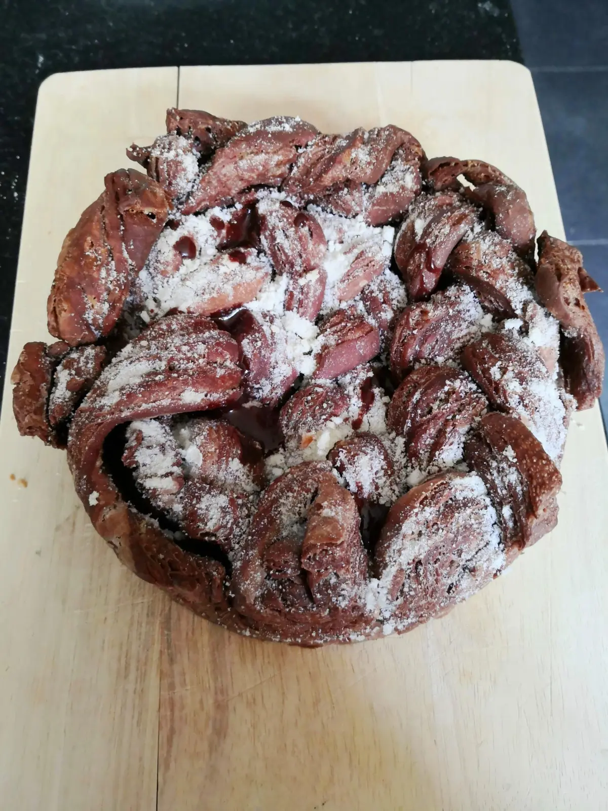 Chocolate-swirl brioche crown dusted with sugar on a wooden board, La Vie Voyage