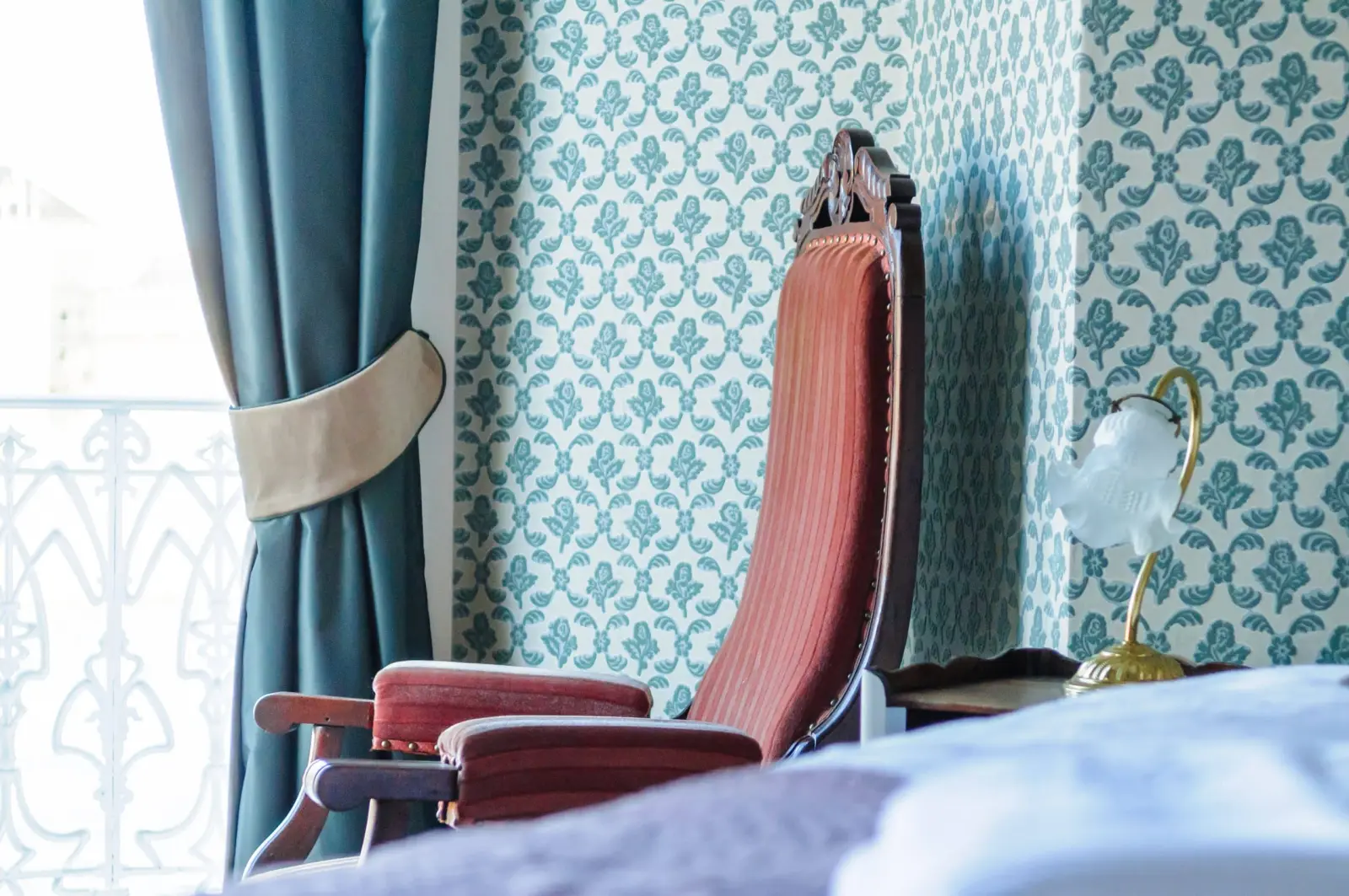 Antique high-backed pink armchair, blue patterned wallpaper and tulip lamp, Villa Balat