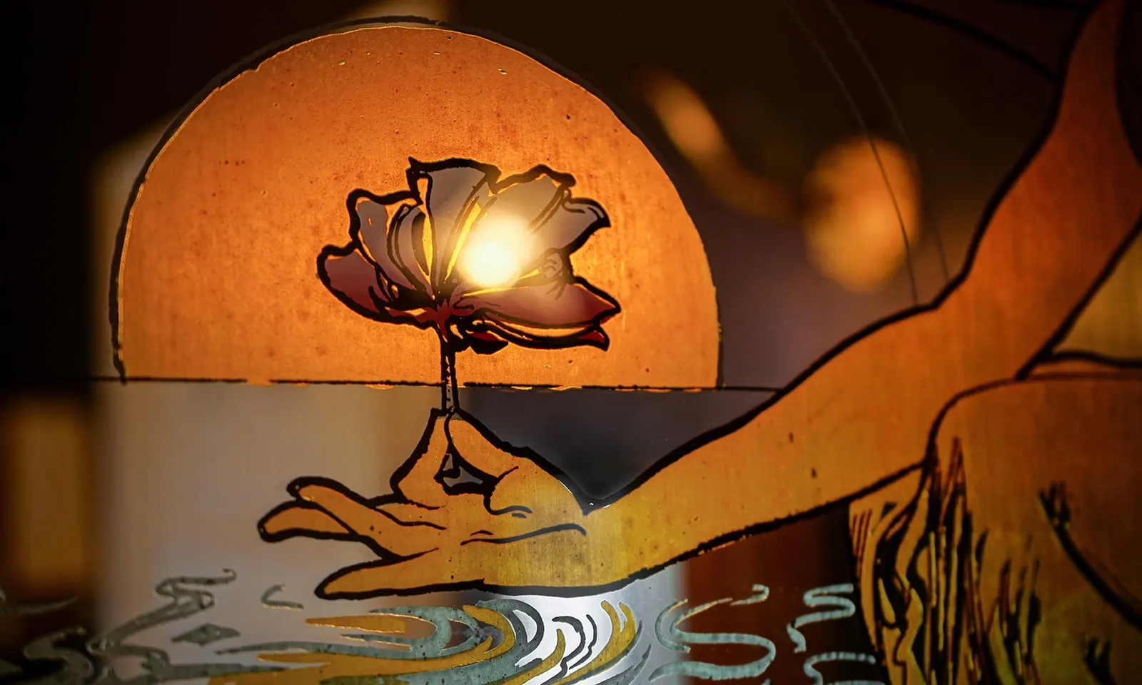 Illuminated illustration of a hand holding a lotus flower in front of an orange sun, Villa Balat