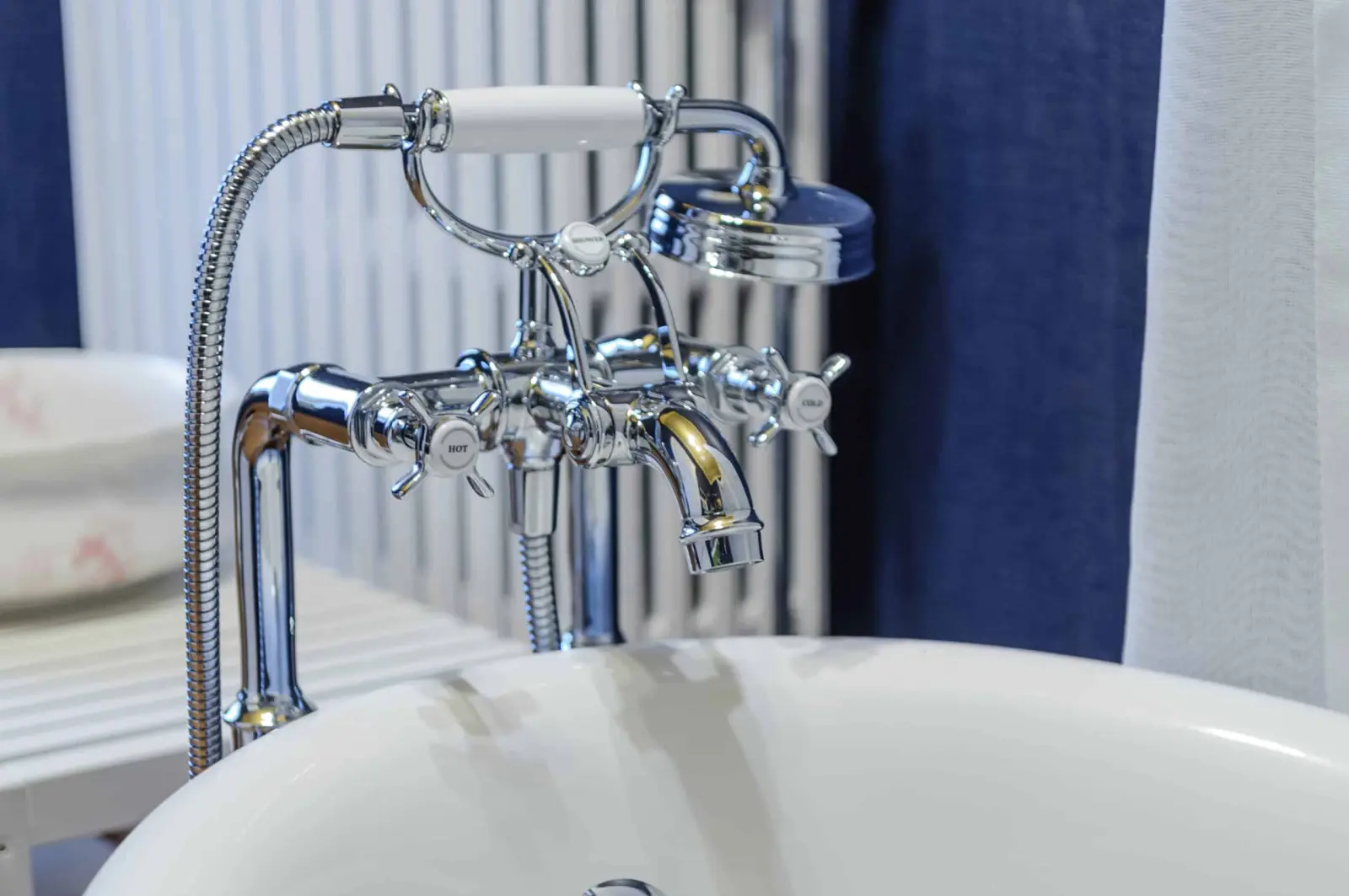 Chrome period-style taps and hand shower above a white bathtub, Villa Balat