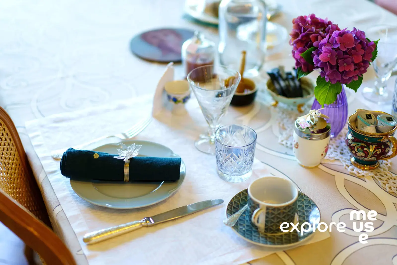 Breakfast table with blue napkin, crystal glasses, cup and a bunch of hydrangeas, Villa Balat