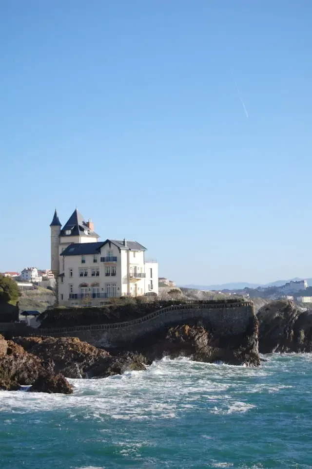 Villa à tourelle perchée sur un promontoire rocheux battu par les vagues de l'océan