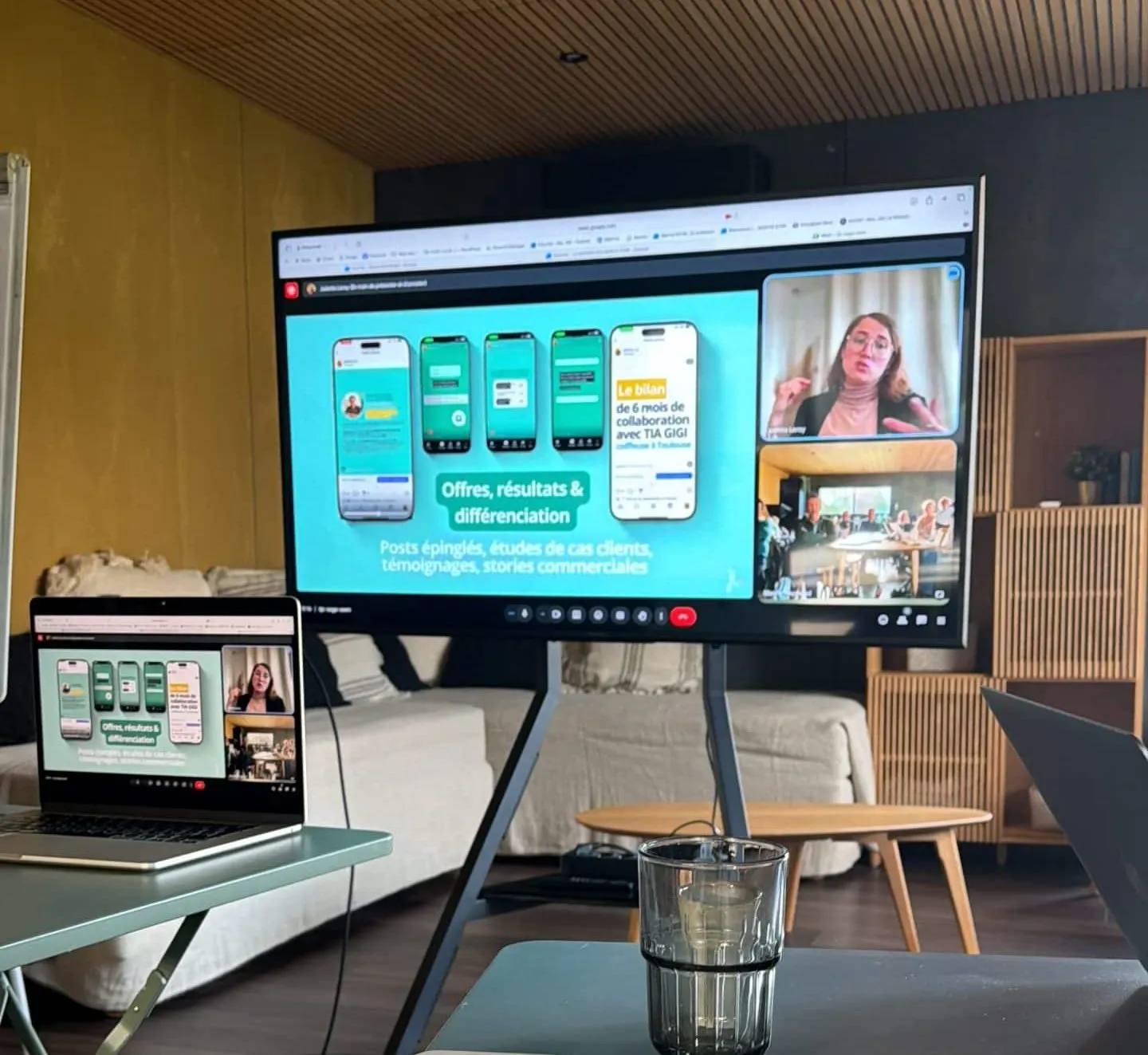 Video-call screen and laptop showing a presentation in a living room